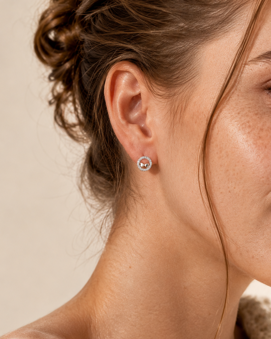 round stud earrings with bow motif and sparkling pavé border #color_silver