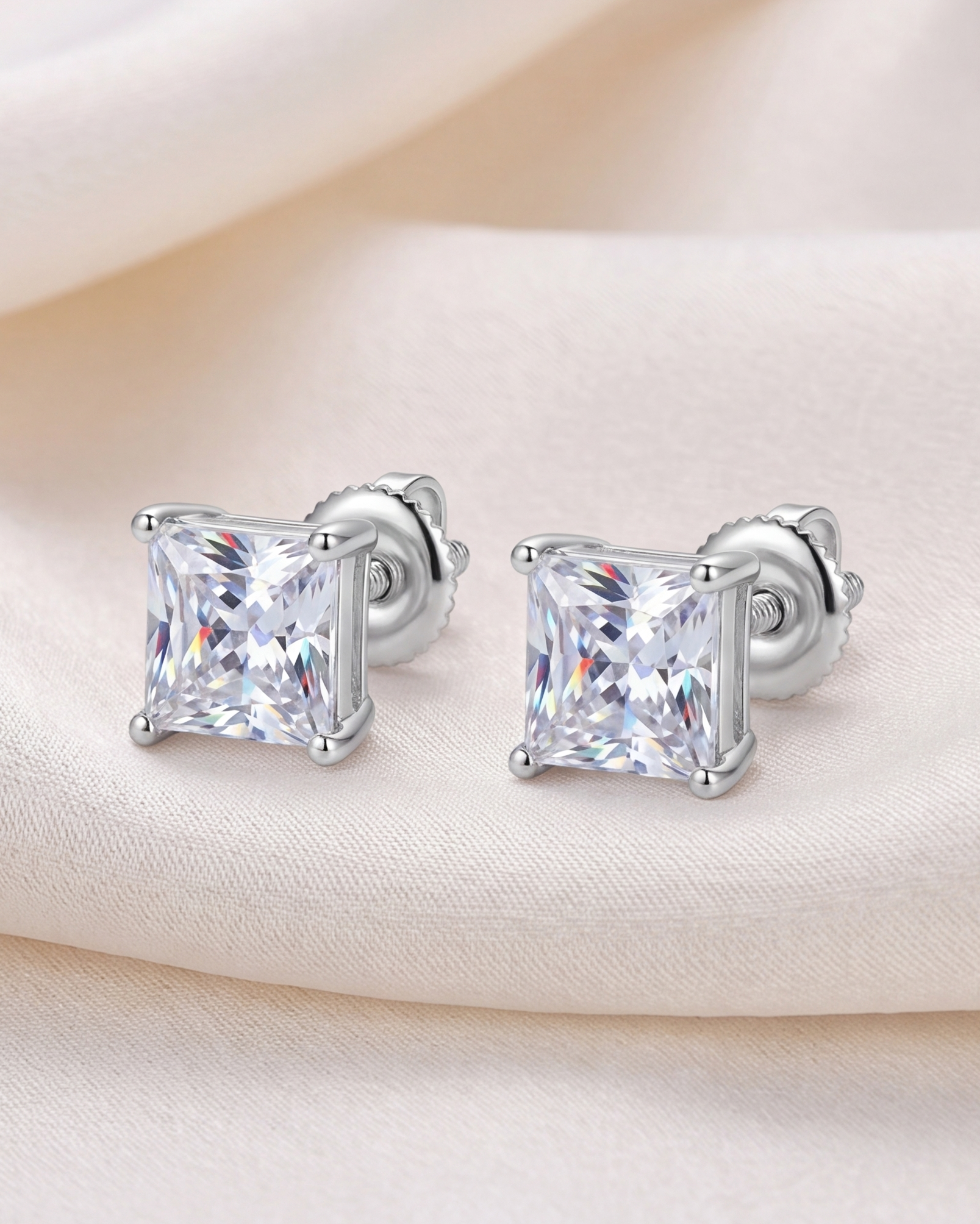 Silver square-cut stud earrings on a soft beige background #color_silver