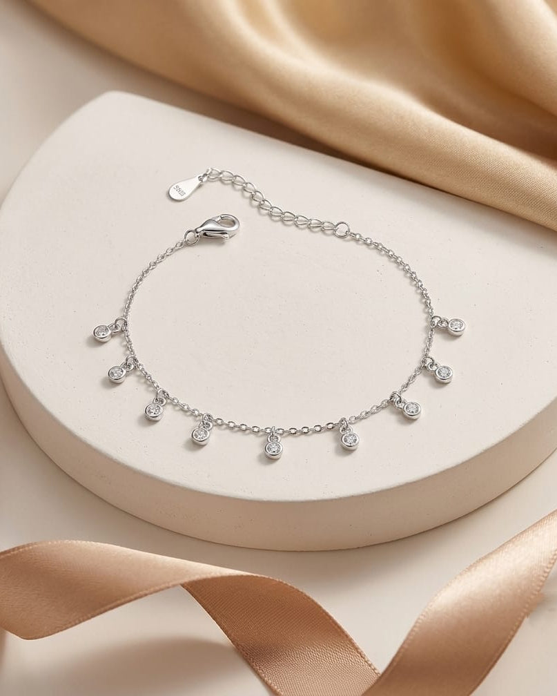 925 Sterling Silver bezel-set drop charm bracelet with white accents.