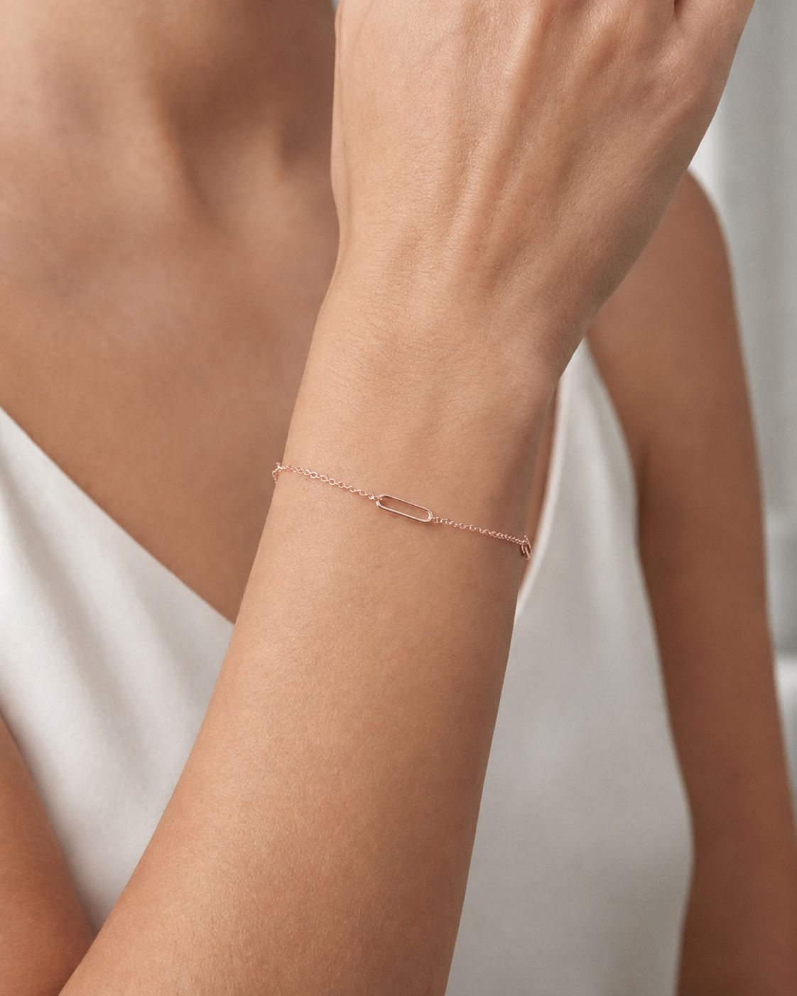 Rose gold bracelet on a wrist with a neutral background #colour_rose gold