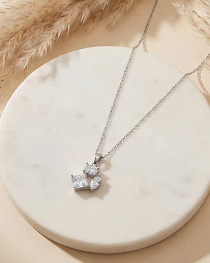 Silver necklace with a heart-shaped pendant on a marble surface #color_silver