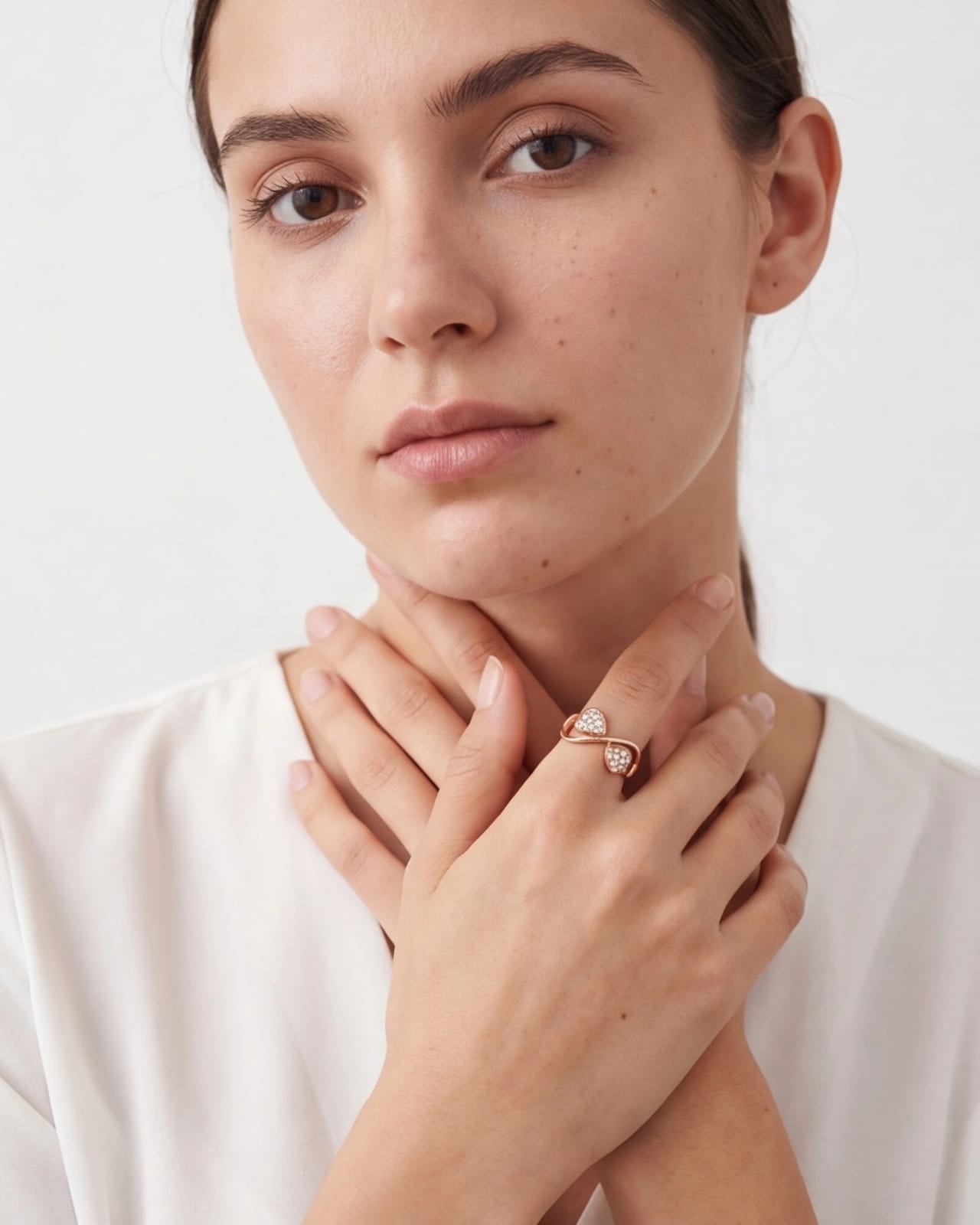 Woman wearing a diamond ring on a plain background #color_rose gold
