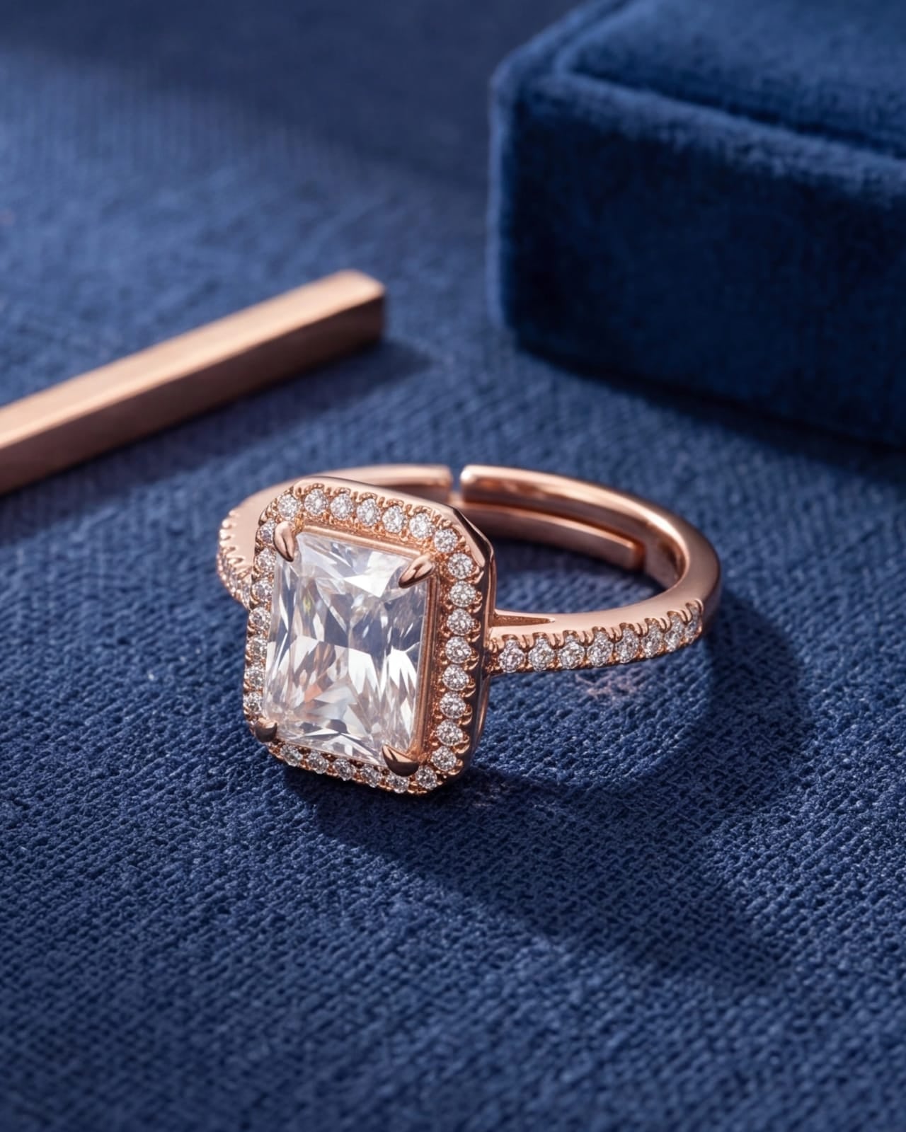 Rose gold ring with a large diamond on a blue fabric background #color_rose gold