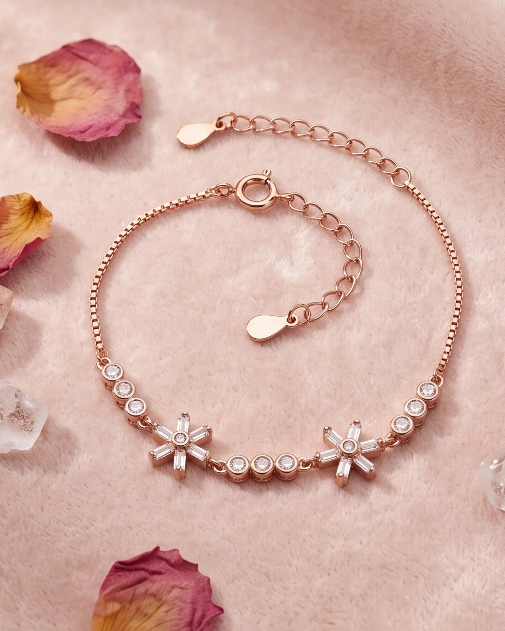 Rose gold bracelet with floral designs on a pink surface with dried flowers and crystals #color_rose gold