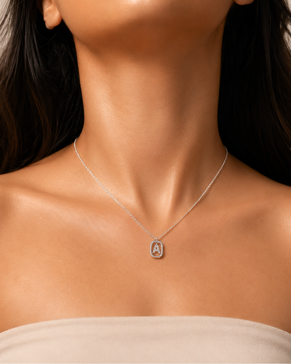 Close-up of a woman wearing a silver necklace with a pendant on a neutral background #color_silver