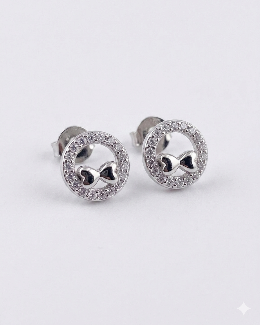 round stud earrings with bow motif and sparkling pavé border #color_silver