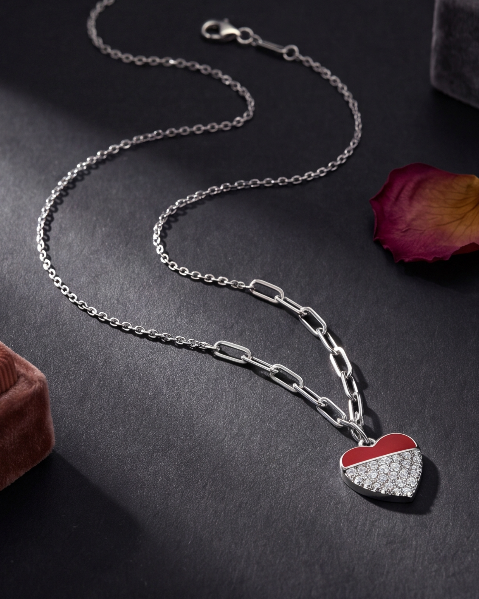 Silver necklace with a heart-shaped pendant on a dark surface #color_silver