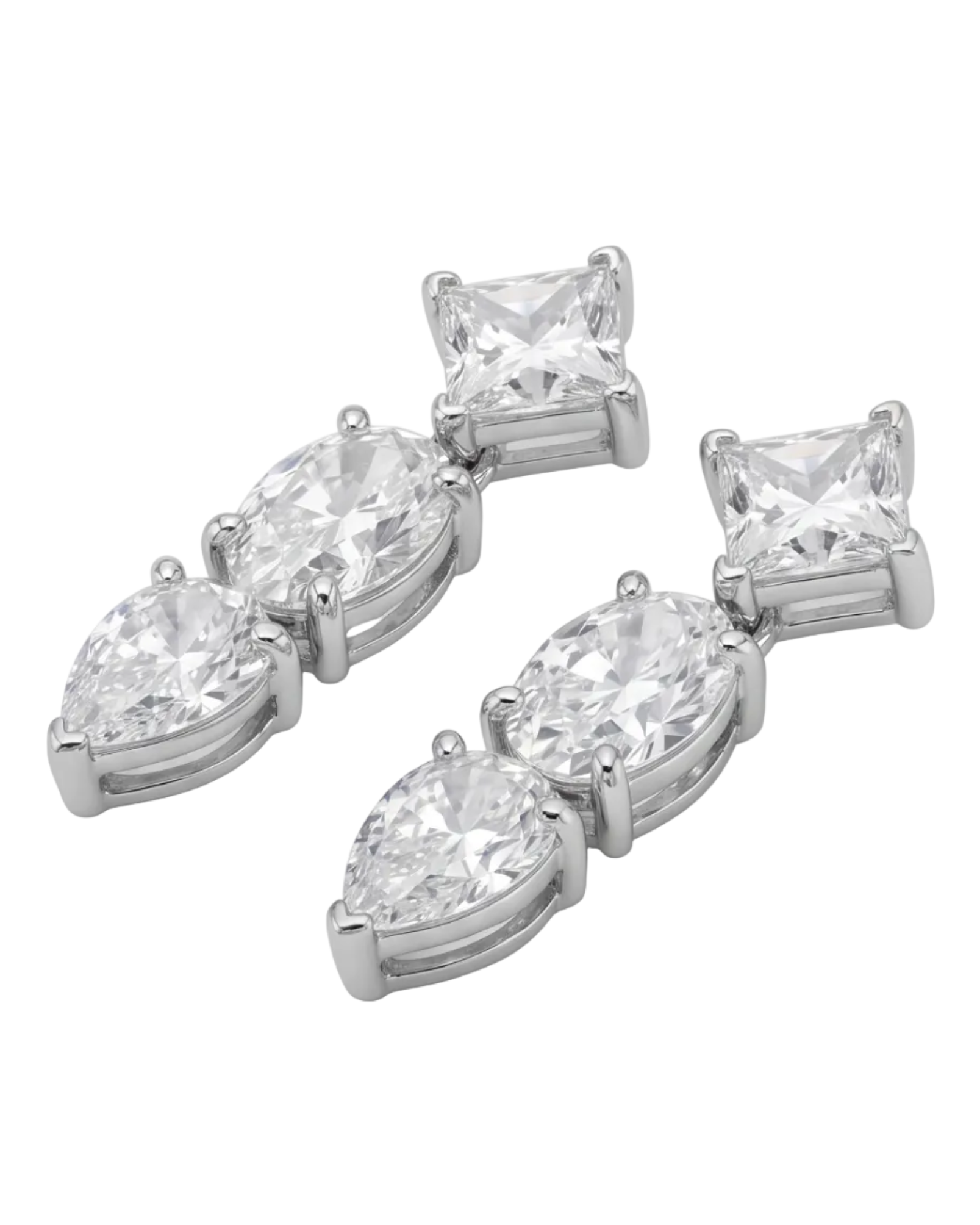 Pair of diamond earrings on a textured surface with a vintage hand mirror. #color_silver