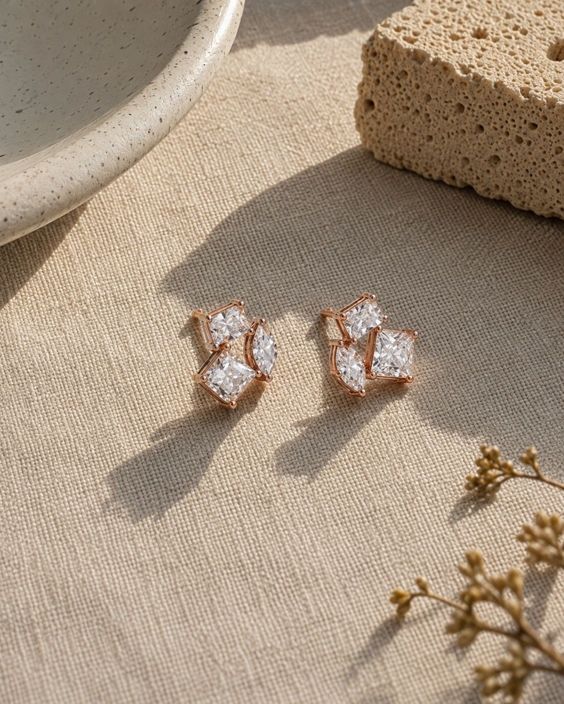 Pair of diamond earrings on a white background  #color_rose gold