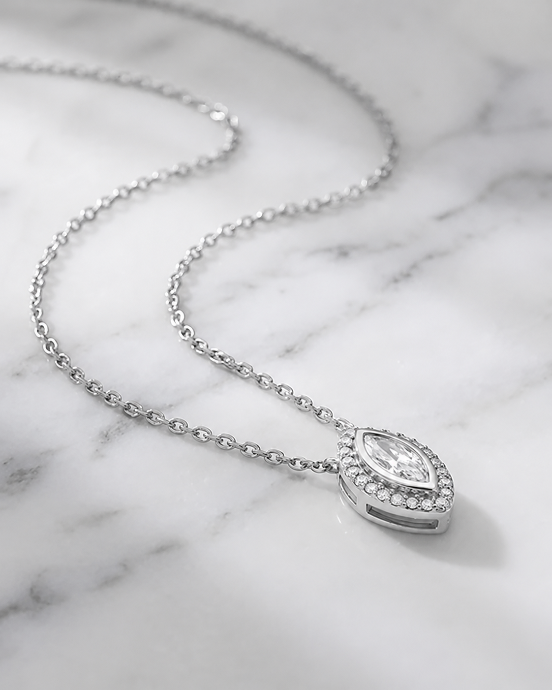 Silver necklace with a teardrop-shaped pendant on a marble surface#color_silver