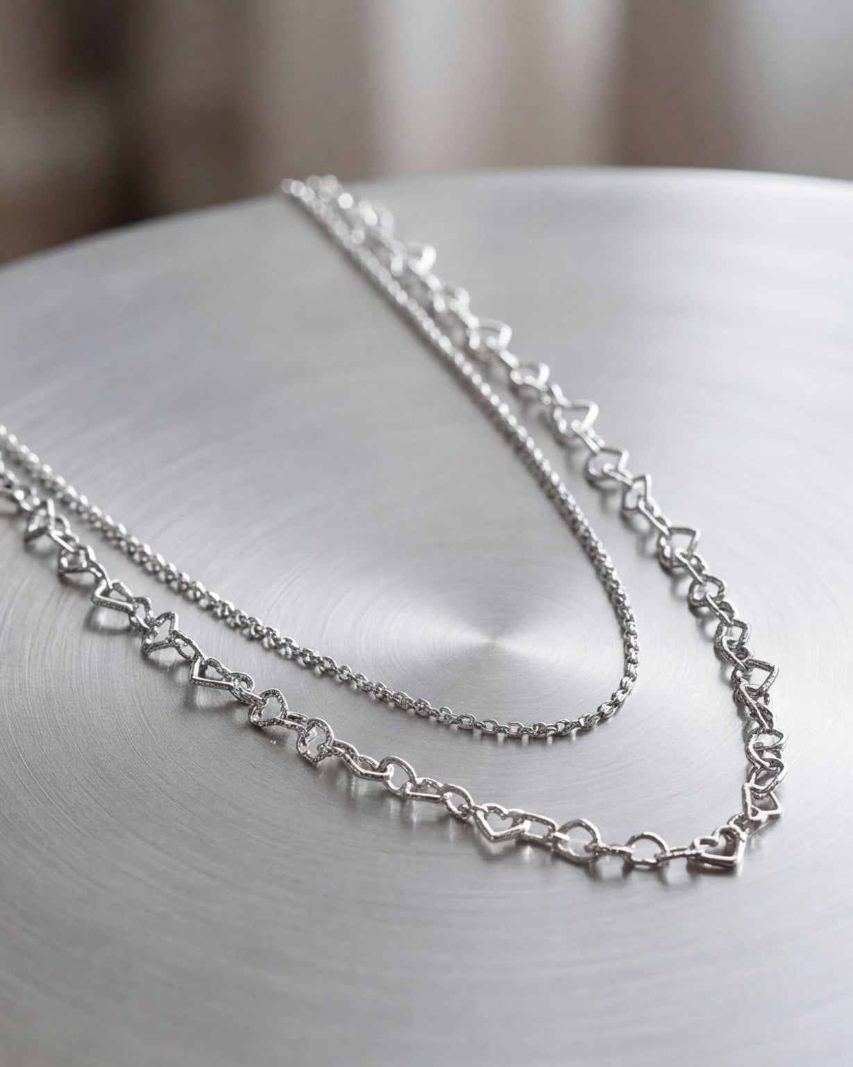 Layered silver necklace with double heart pendants #color_silver