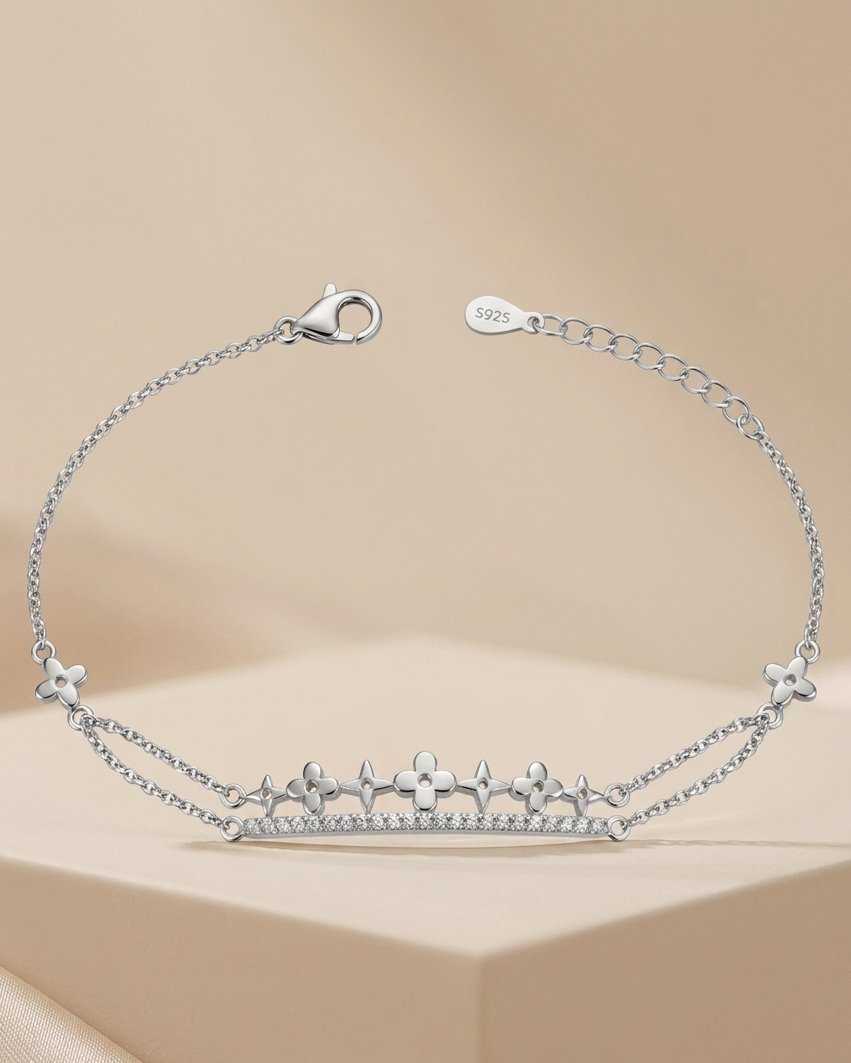 Silver bracelet with star and heart designs on a beige background #colour silver