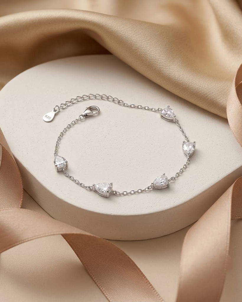 925 Sterling Silver pear-cut station chain bracelet with adjustable lobster clasp.