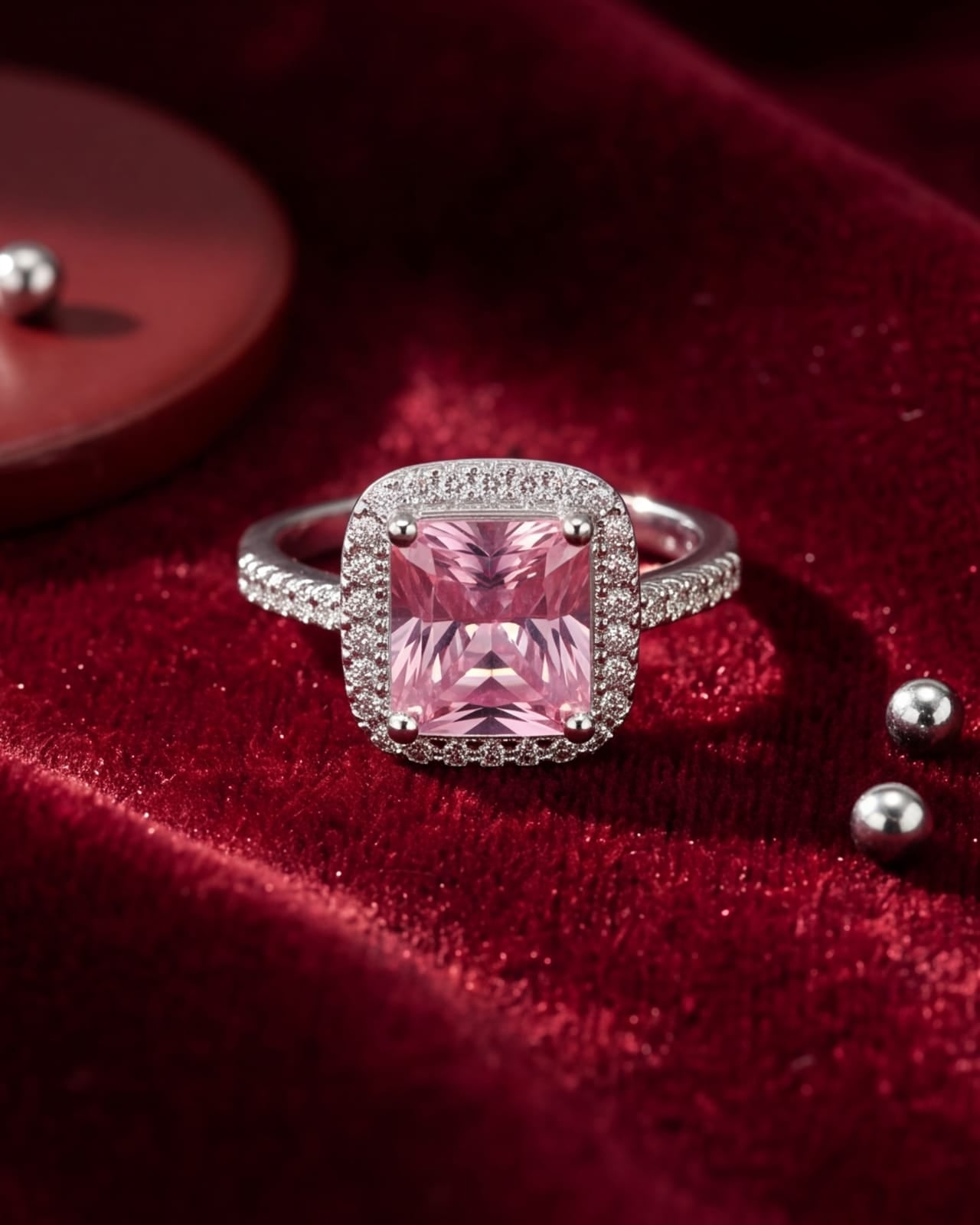 Pink gemstone ring with diamond accents on a red velvet background #color_silver