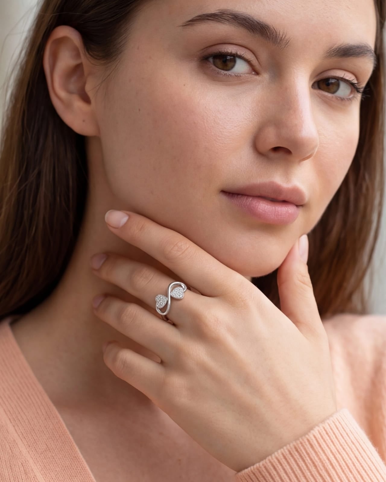 Woman wearing a ring with an infinity symbol, close-up of face and hand #color_silver