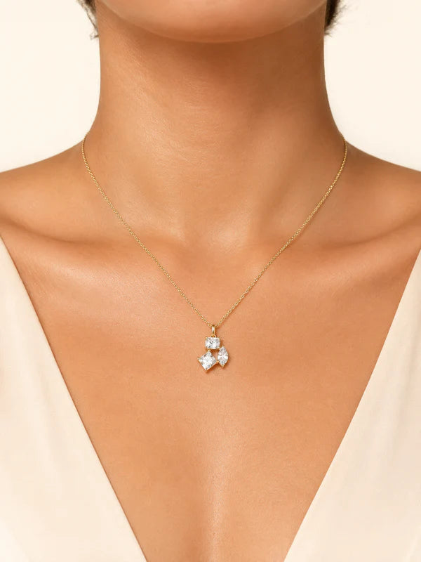 Gold necklace with a star-shaped pendant on a model wearing a beige top #color_gold