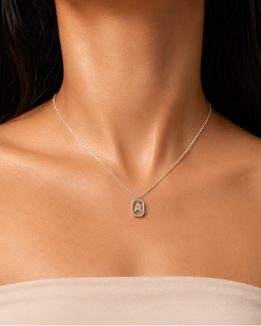 Close-up of a woman wearing a silver necklace with a pendant on a neutral background #color_silver