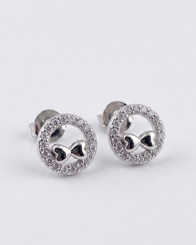 round stud earrings with bow motif and sparkling pavé border #color_silver